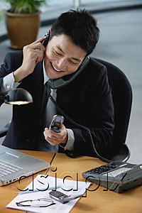 AsiaPix - A man sits at his desk with lots of phones