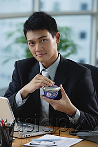 AsiaPix - A man looks at the camera as he as he holds a Chinese tea cup