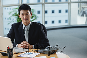 AsiaPix - A man looks at the camera as he sits at his desk
