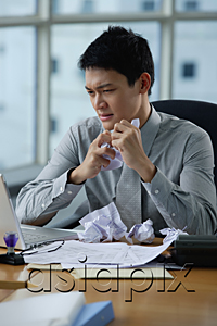 AsiaPix - A man looks stressed as he works at his desk