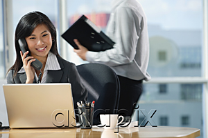 AsiaPix - A woman talks on the phone as she sits at her desk