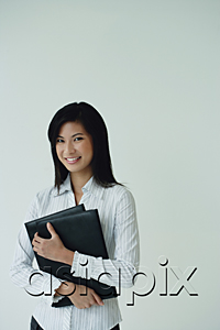 AsiaPix - A businesswoman looks at the camera as she holds a folder