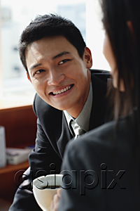 AsiaPix - A man smiles as he has coffee with a woman