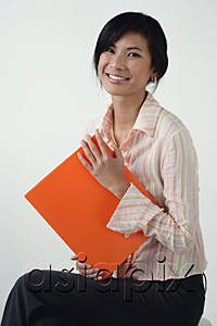 AsiaPix - A woman smiles at the camera as she holds an orange folder
