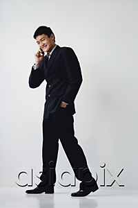 AsiaPix - A man in a suit smiles as he talks on his cellphone