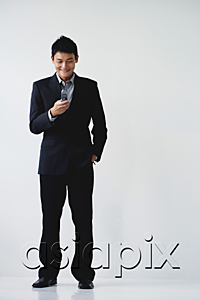 AsiaPix - A man wearing a suit smiles as he dials on his cellphone