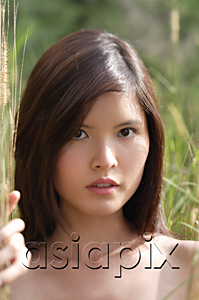 AsiaPix - Woman in long grass looking at camera