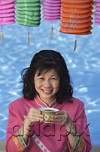 AsiaPix - Woman drinking tea, surrounded by Chinese lanterns