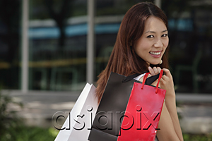 AsiaPix - Woman with shopping bags, smiling over shoulder at camera