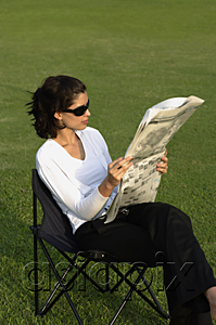 AsiaPix - Women on chair, reading newspaper