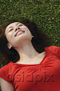 AsiaPix - Woman smiling, lying on grass