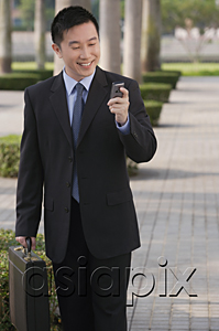 AsiaPix - Businessman smiling while looking at mobile phone