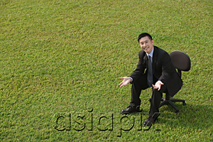 AsiaPix - Businessman in office chair, smiling at camera
