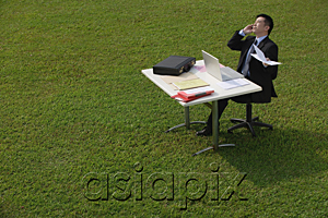 AsiaPix - Businessman on the phone while sitting at desk