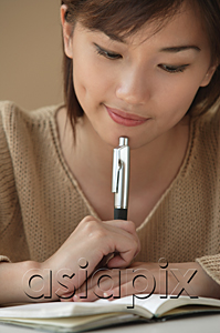 AsiaPix - Young woman looking at notebook