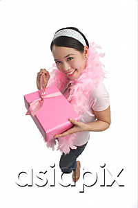 AsiaPix - Young woman holding present and smiling at camera