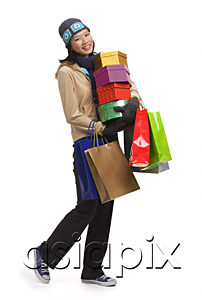 AsiaPix - Young woman with gift boxes and shopping bags, smiling at camera