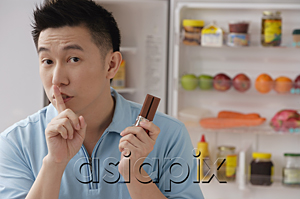 AsiaPix - Man shushing while holding chocolate