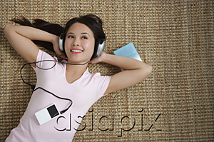 AsiaPix - Young woman listening to music while lying down