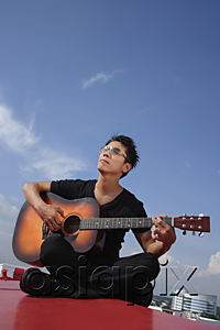 AsiaPix - Man playing guitar outdoors