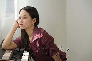 AsiaPix - Young woman leaning on keyboard, looking bored