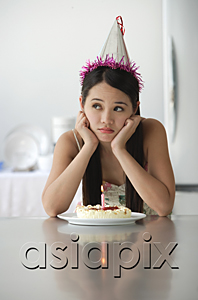 AsiaPix - Young woman with birthday cake looking bored