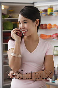 AsiaPix - Young woman holding apple and smiling