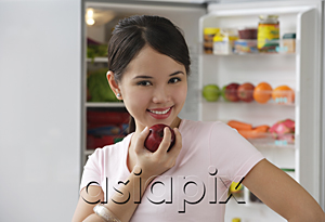 AsiaPix - Young woman holding apple and smiling at camera