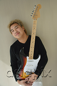AsiaPix - Man with guitar smiling at camera