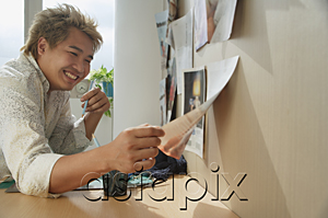 AsiaPix - Man at desk smiling while looking at paper