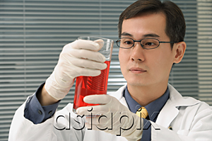 AsiaPix - Scientist examining container of fluid