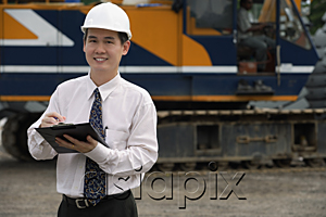 AsiaPix - Man with hard helmet and clipboard looking at camera