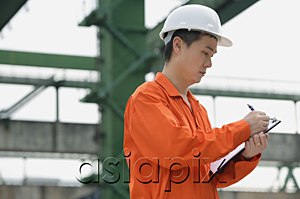 AsiaPix - Construction worker making notes on clipboard