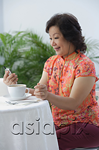 AsiaPix - Mature woman having tea and listening to music
