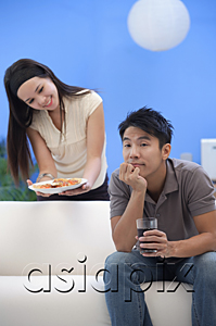 AsiaPix - Young woman offering man a plate of food