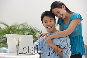 AsiaPix - Young woman leaning on shoulder of man at the computer