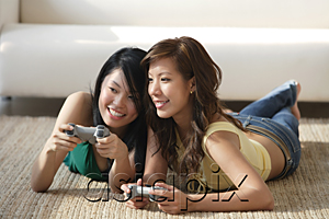 AsiaPix - Young women lying on the floor, playing video games