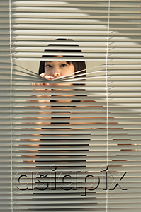 AsiaPix - Young woman behind Venetian blinds