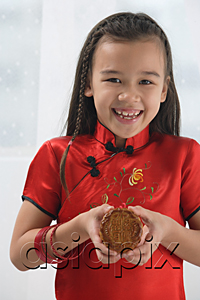 AsiaPix - Young girl in traditional Chinese dress holding cookie and smiling at camera