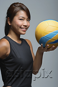 AsiaPix - Young woman with volleyball smiling at camera