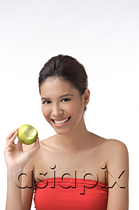 AsiaPix - Young woman smiling at camera holding apple