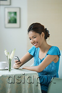 AsiaPix - Young woman sitting in restaurant