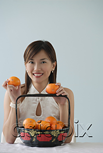 AsiaPix - Young woman with fruit smiling at camera