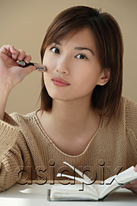 AsiaPix - Young woman with journal looking at camera