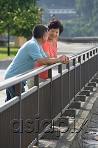 AsiaPix - Couple having a conversation while leaning in fence