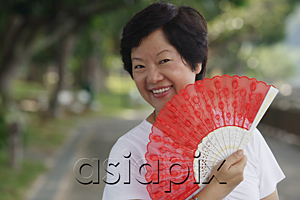 AsiaPix - Woman with fan smiling at camera