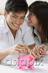 AsiaPix - Young couple with piggy bank