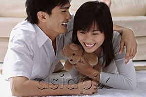 AsiaPix - Young couple laughing while hugging and lying on the floor