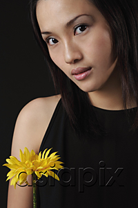 AsiaPix - Young woman with flower looking at camera