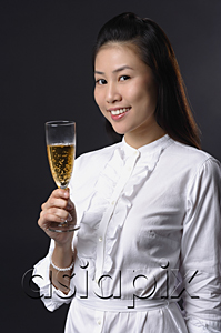 AsiaPix - Young woman toasting with champagne and looking at camera